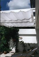 Toldo montado entre casa e viga exterior de prgula